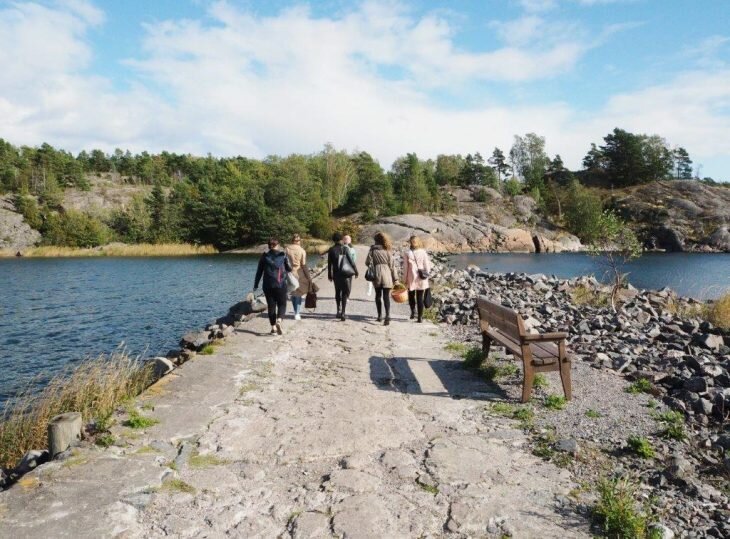 A group of people walking towards the Nolla Cabin in Vallisaari to have a zero waste picnic.